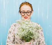 Thumb_stocksy-bonninstudio-woman-holding-flowers-in-front-of-blue-background